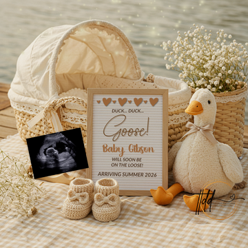 Baby reveal decoration with a baby booties, ultrasound photo, sign, and plush duck.