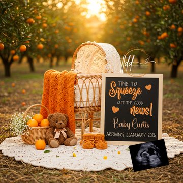 Baby announcement setup with baby shoes, teddy bear, and sign in an orange orchard.